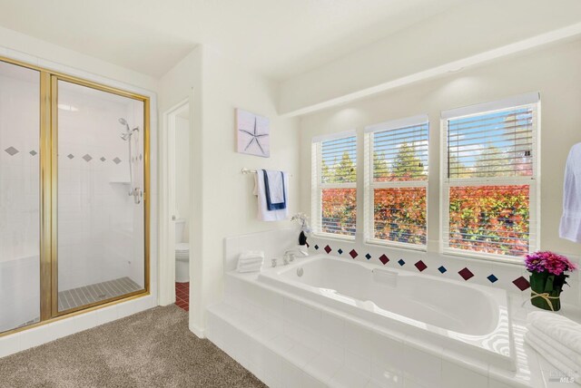 full bath featuring a garden tub, a stall shower, and toilet