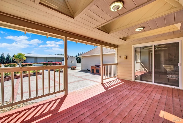 wooden terrace with a storage unit and an outdoor structure