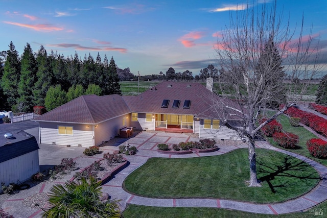 ranch-style home featuring a lawn, a porch, a patio, and a shed