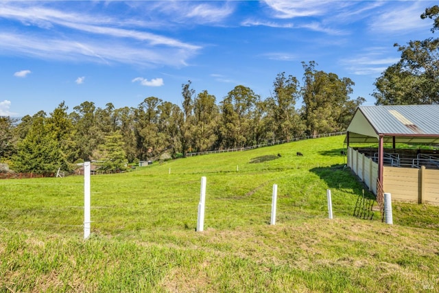 view of yard featuring an exterior structure, an outdoor structure, and a rural view