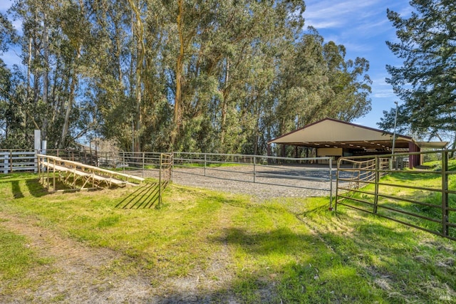 view of yard with a rural view, an outdoor structure, and an exterior structure
