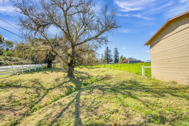 view of yard featuring fence and a rural view