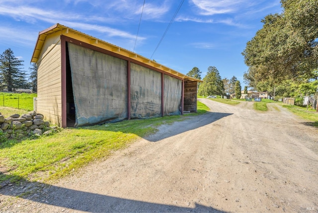 view of pole building with dirt driveway