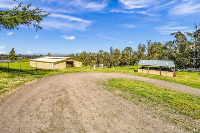 view of road with an exterior structure, an outbuilding, and a rural view