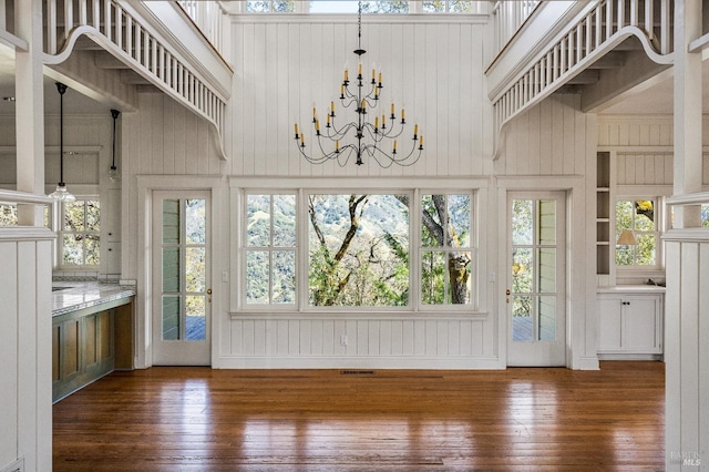 interior space with dark hardwood / wood-style flooring, a chandelier, and a high ceiling