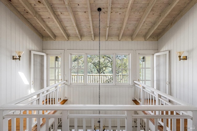 unfurnished sunroom featuring beamed ceiling and wooden ceiling