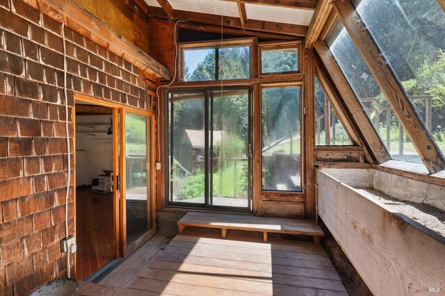 unfurnished sunroom featuring lofted ceiling