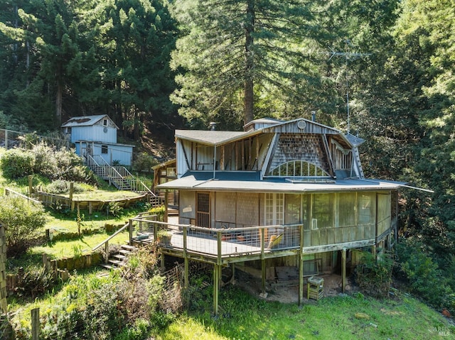 back of house featuring a shed and a deck