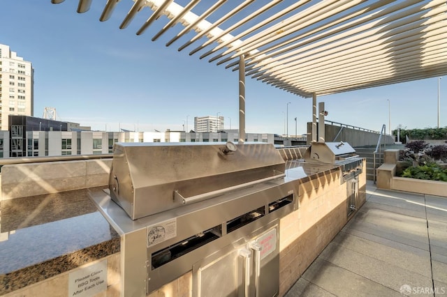 view of patio / terrace featuring a pergola, grilling area, and exterior kitchen