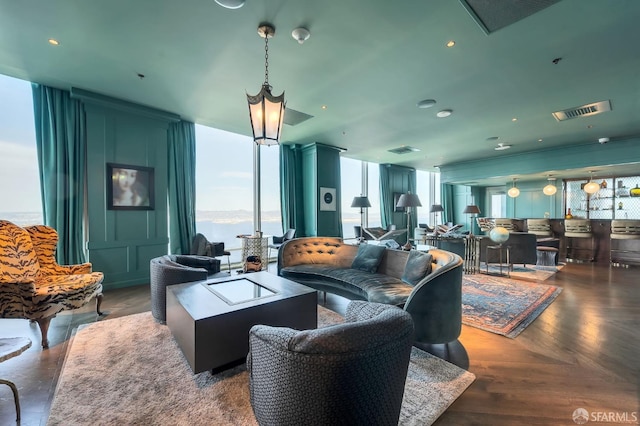 living room featuring expansive windows, a water view, and dark parquet floors