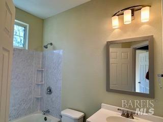 full bathroom featuring vanity, bathing tub / shower combination, and toilet