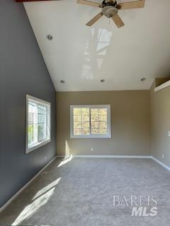 carpeted empty room featuring vaulted ceiling and ceiling fan