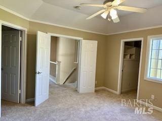 unfurnished bedroom featuring light carpet, vaulted ceiling, ornamental molding, and ceiling fan