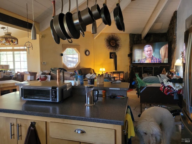 kitchen with wooden ceiling, a wood stove, lofted ceiling with beams, and a healthy amount of sunlight