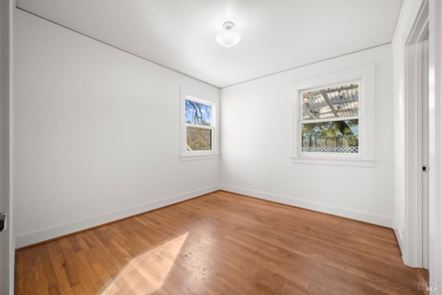 unfurnished room featuring hardwood / wood-style floors and plenty of natural light