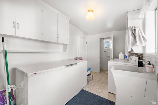 clothes washing area with cabinets, separate washer and dryer, plenty of natural light, and sink