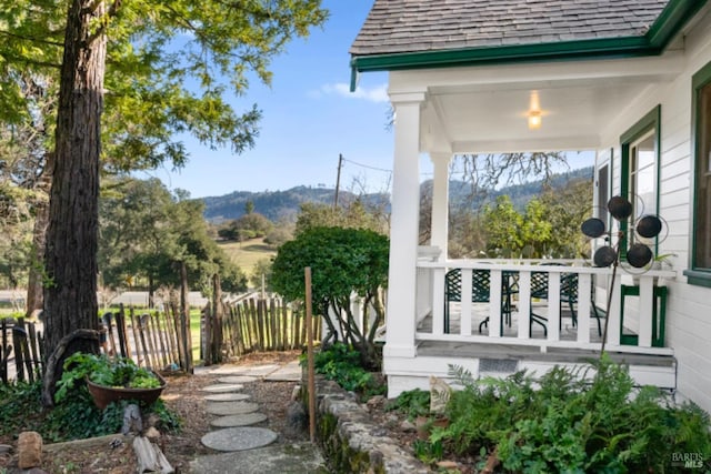 view of yard with covered porch and a mountain view