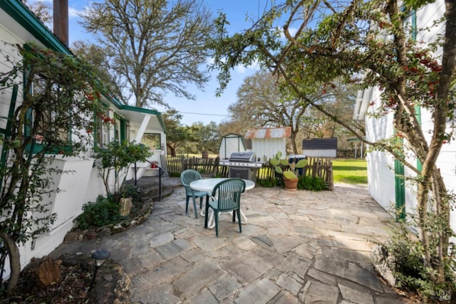 view of patio with grilling area and a storage unit