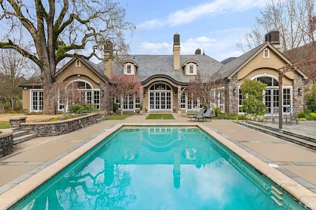 view of pool with french doors and a patio