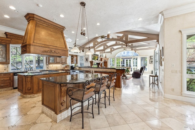 kitchen with a kitchen island, plenty of natural light, pendant lighting, and lofted ceiling