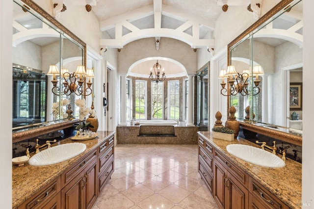 bathroom with double sink vanity, vaulted ceiling, a bathtub, tile flooring, and a notable chandelier