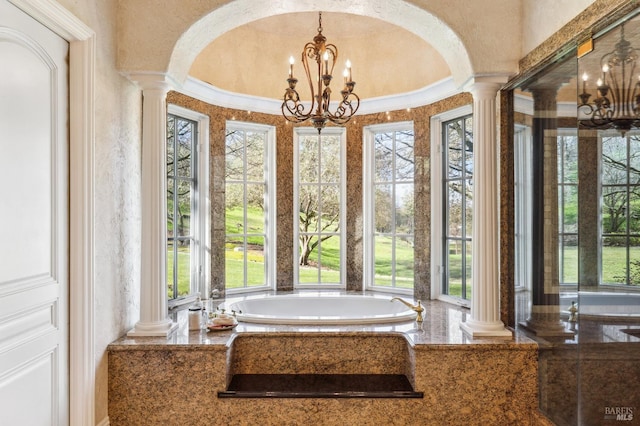 entryway with ornamental molding, plenty of natural light, decorative columns, and a chandelier