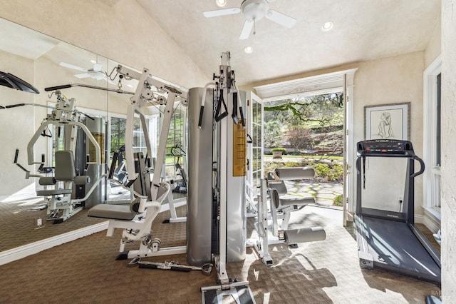 exercise room with vaulted ceiling, dark colored carpet, and ceiling fan