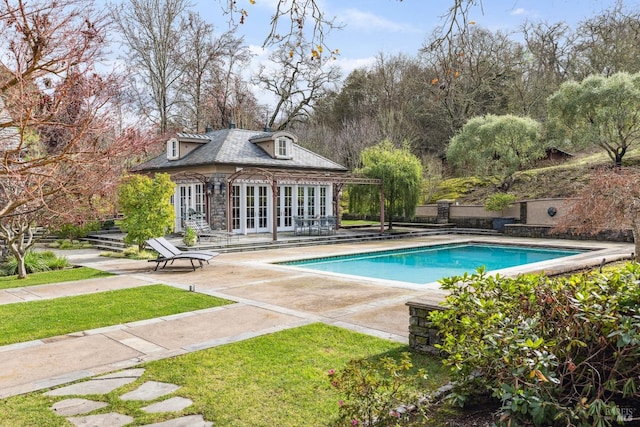 view of swimming pool with a patio, an outdoor structure, and french doors