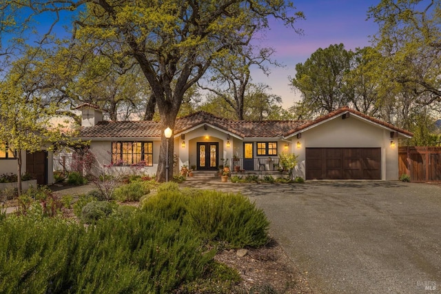 mediterranean / spanish-style home with french doors and a garage