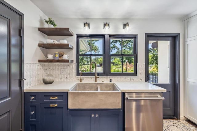 kitchen featuring dishwasher, tasteful backsplash, blue cabinetry, and sink