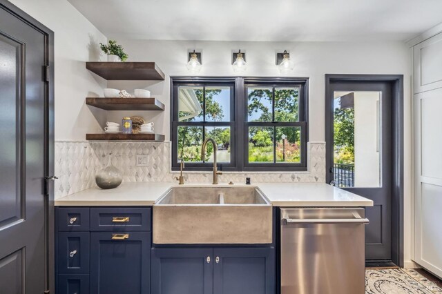 kitchen with tasteful backsplash, dishwasher, sink, and blue cabinetry