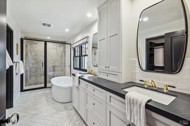 bathroom with decorative backsplash, vanity, and shower with separate bathtub