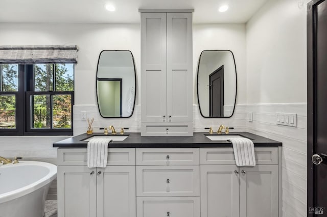 bathroom featuring a bathing tub, vanity, and decorative backsplash