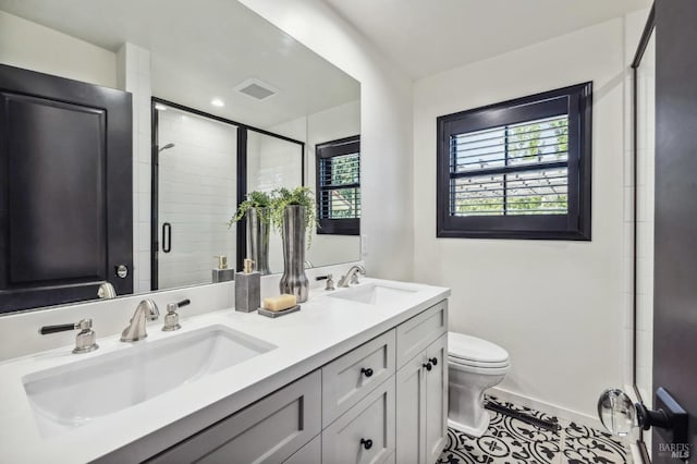 bathroom with tile patterned floors, vanity, toilet, and a shower with shower door