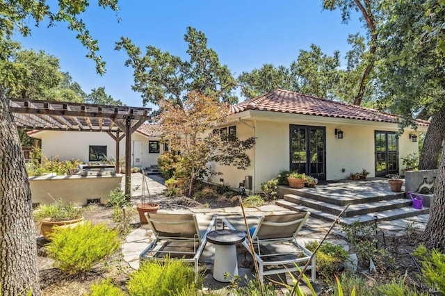 rear view of house featuring a patio area, a pergola, and french doors