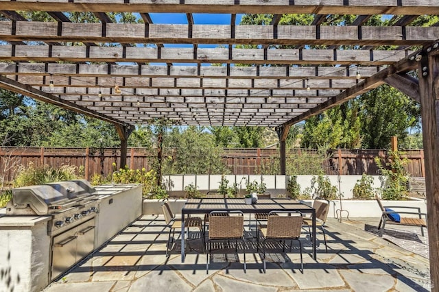 view of patio featuring an outdoor kitchen, a grill, and a pergola