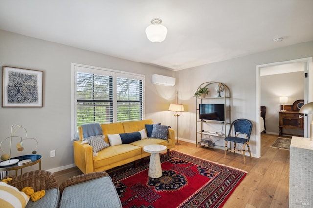 living room with a wall unit AC and light hardwood / wood-style flooring