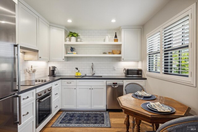 kitchen featuring white cabinetry, sink, backsplash, and stainless steel appliances