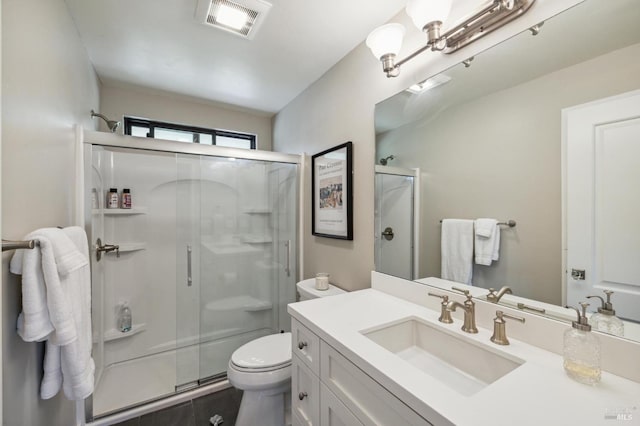 bathroom featuring vanity, a shower with shower door, and toilet