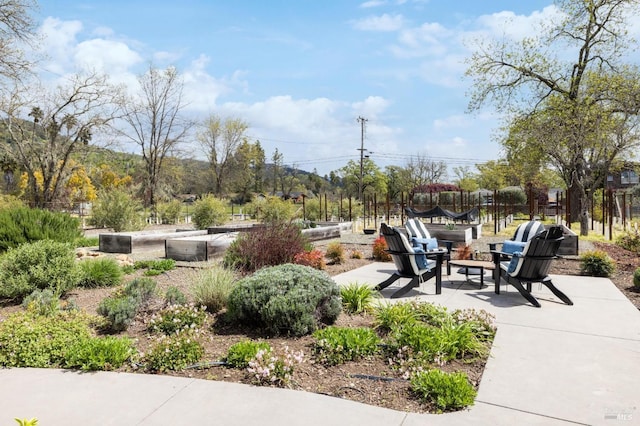 view of property's community featuring a patio and a fire pit