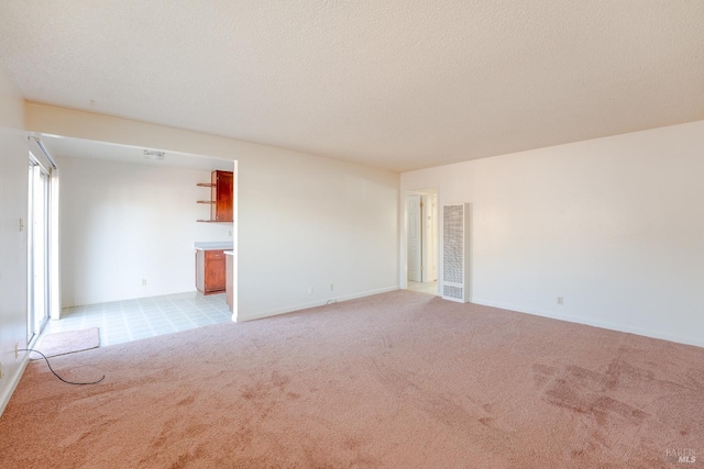 carpeted empty room with a textured ceiling