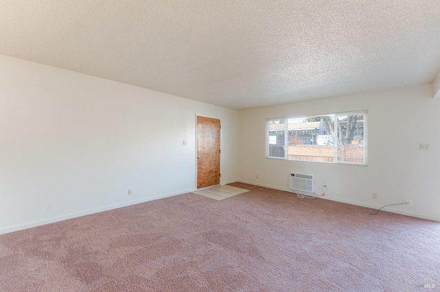 carpeted spare room featuring a textured ceiling and a wall mounted AC