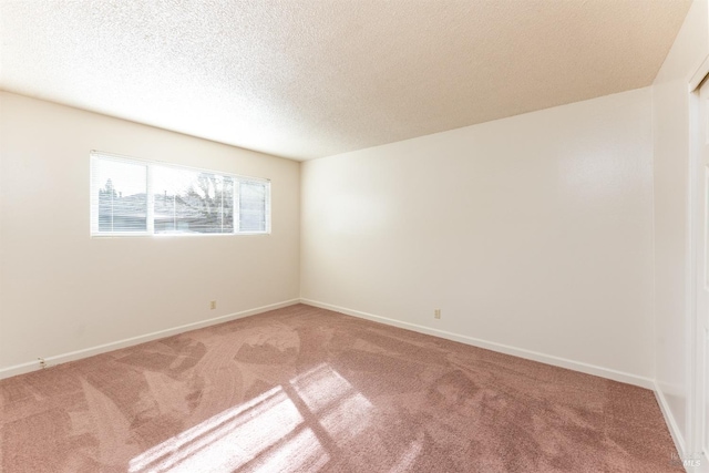 spare room featuring carpet floors and a textured ceiling