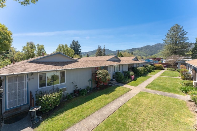 single story home featuring a mountain view and a front yard