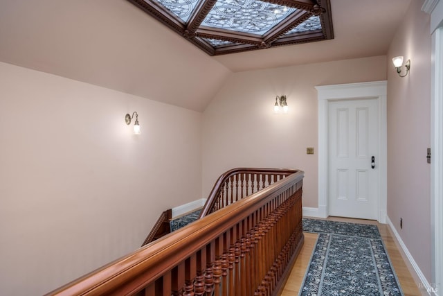 hall featuring a skylight and light hardwood / wood-style floors