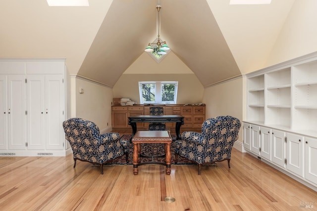 sitting room with built in features, vaulted ceiling, and light wood-type flooring