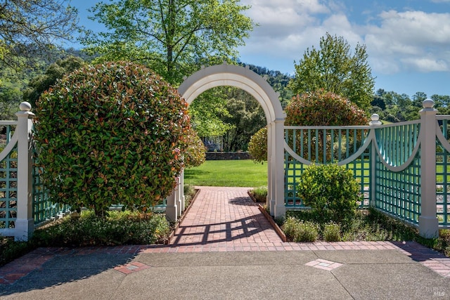 view of gate with a lawn