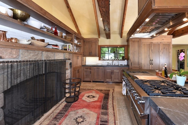 kitchen with backsplash, stainless steel stove, vaulted ceiling with beams, light tile flooring, and wall chimney range hood