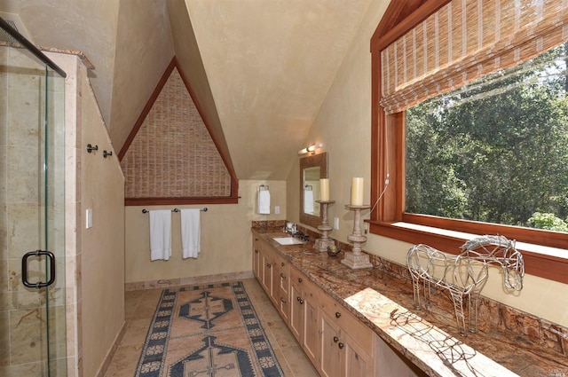 bathroom with dual bowl vanity, an enclosed shower, and vaulted ceiling