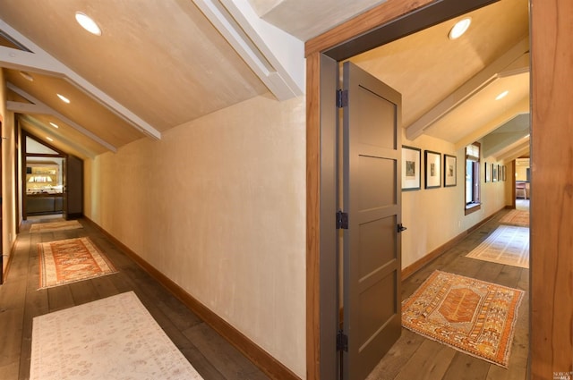 corridor with dark hardwood / wood-style floors and lofted ceiling with beams